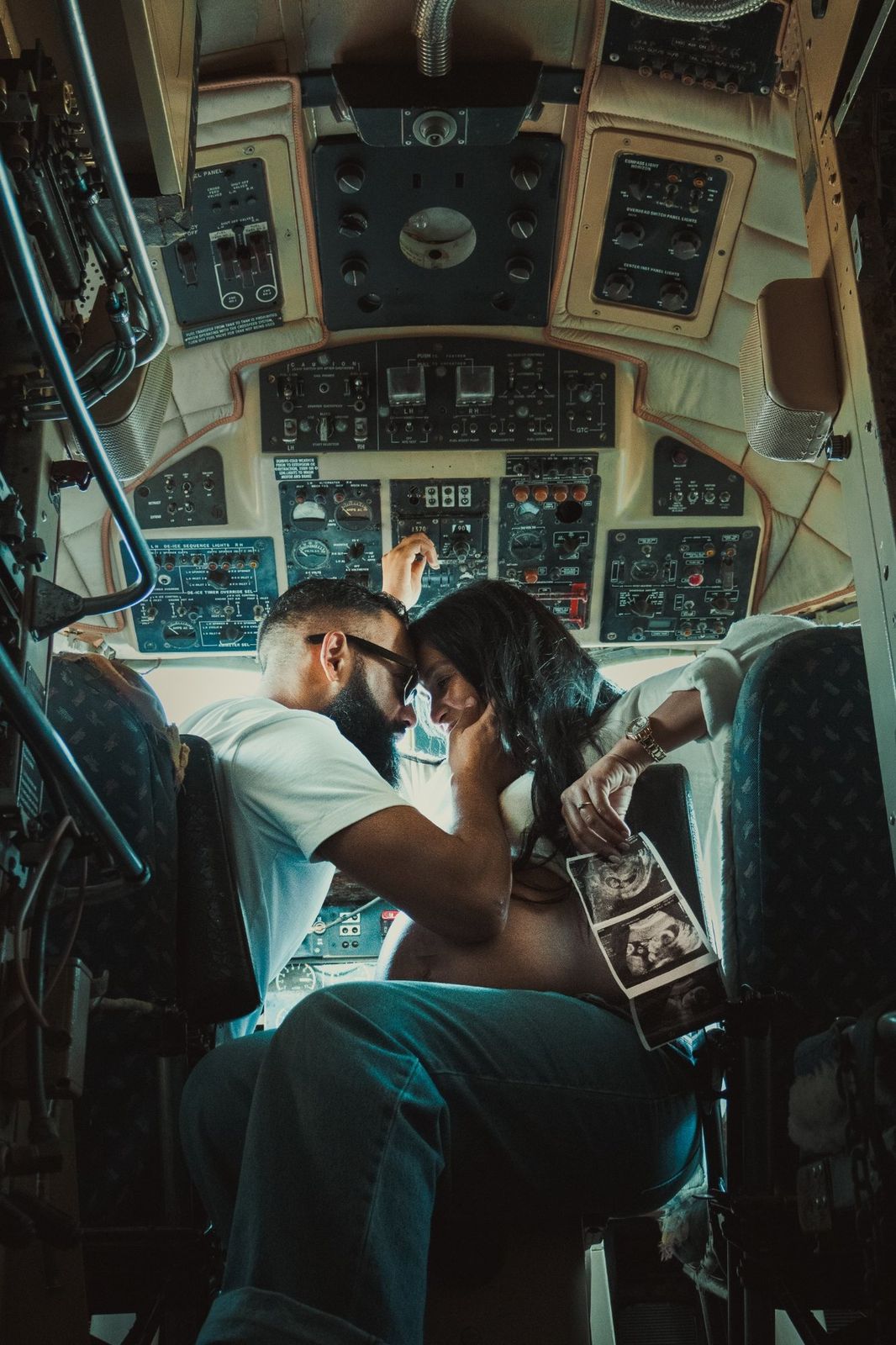 Cinematic maternity portrait inside an aircraft cockpit